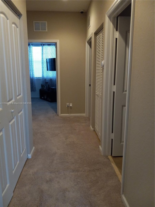 hallway with light colored carpet