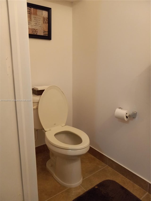 bathroom with toilet and tile patterned floors