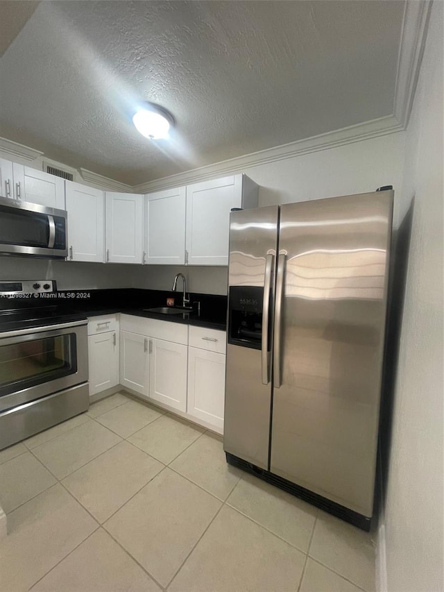 kitchen with white cabinets, sink, ornamental molding, a textured ceiling, and stainless steel appliances