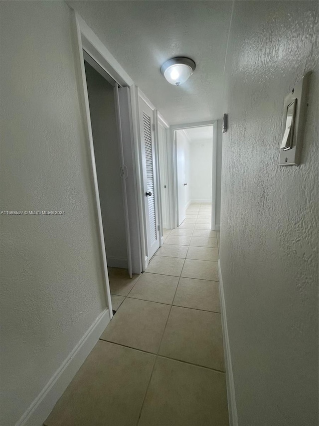 hall with light tile patterned floors