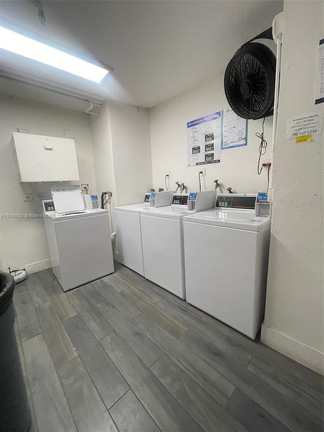 clothes washing area with hardwood / wood-style flooring and washer and clothes dryer