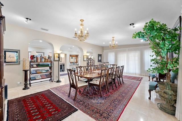 tiled dining area featuring crown molding and an inviting chandelier