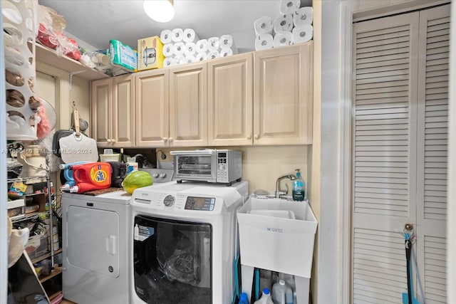 laundry area featuring washer and dryer, cabinets, and sink