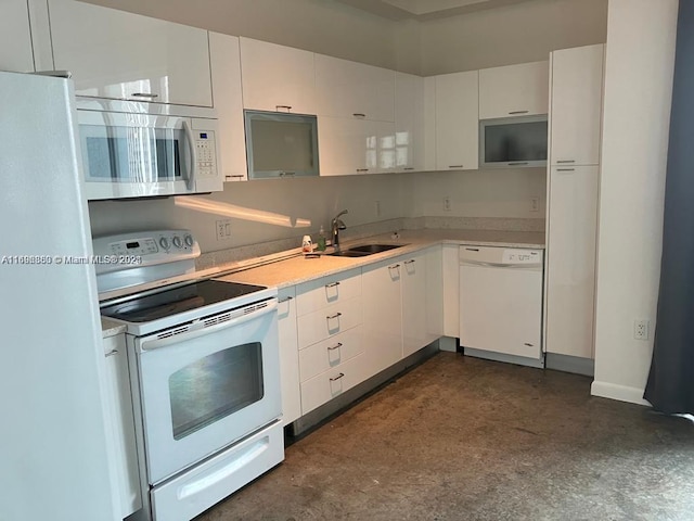 kitchen featuring sink, white cabinets, and white appliances