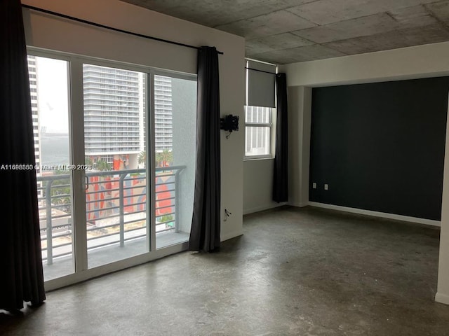 spare room featuring a healthy amount of sunlight and concrete flooring