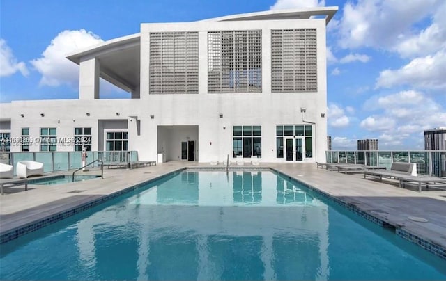 rear view of property with a patio area and a community pool