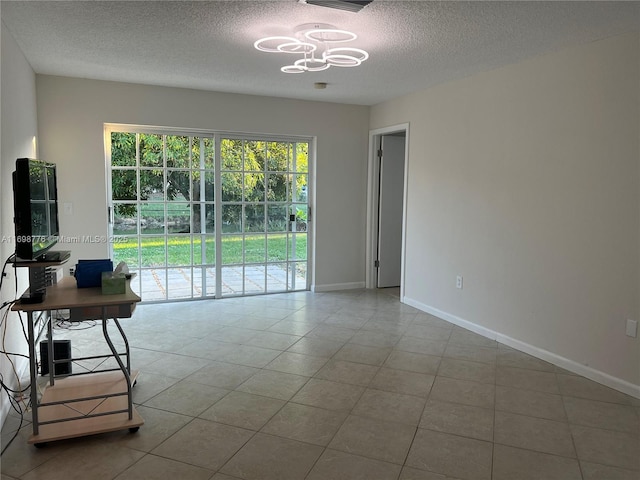 interior space featuring a notable chandelier, a textured ceiling, and light tile patterned floors