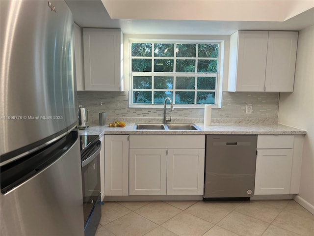 kitchen featuring white cabinetry, sink, light tile patterned floors, and black appliances