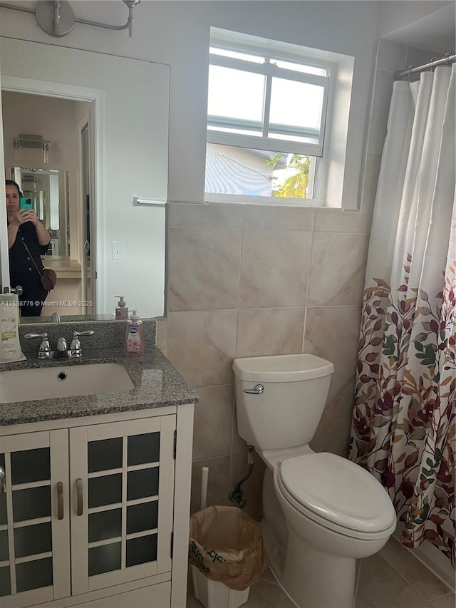 bathroom featuring tile walls, vanity, walk in shower, toilet, and tile patterned floors