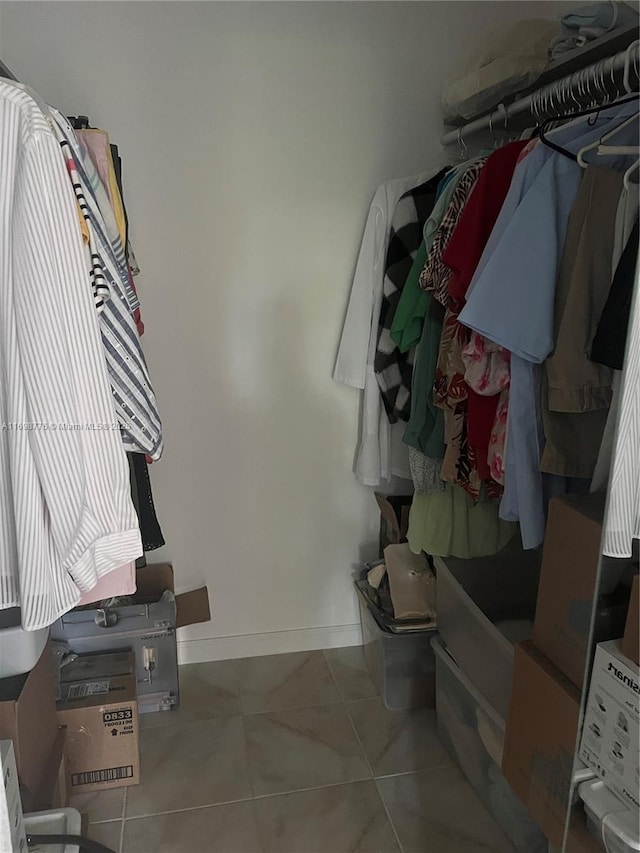 walk in closet with light tile patterned floors