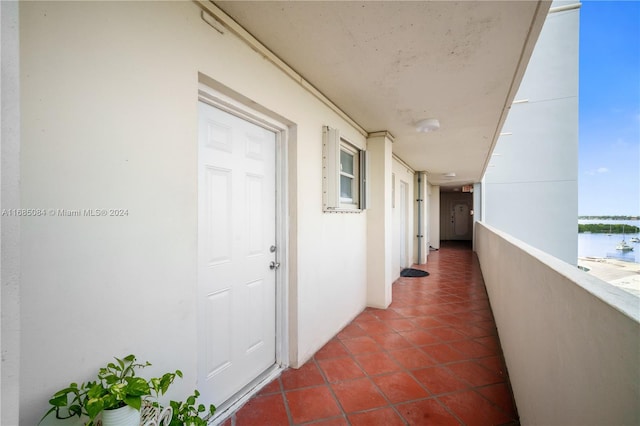 hallway with a water view and dark tile patterned flooring