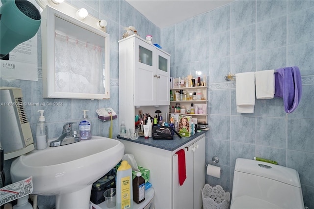 bathroom featuring toilet and tile walls