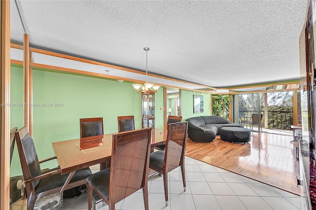 dining area with a baseboard heating unit, a textured ceiling, and light tile patterned floors