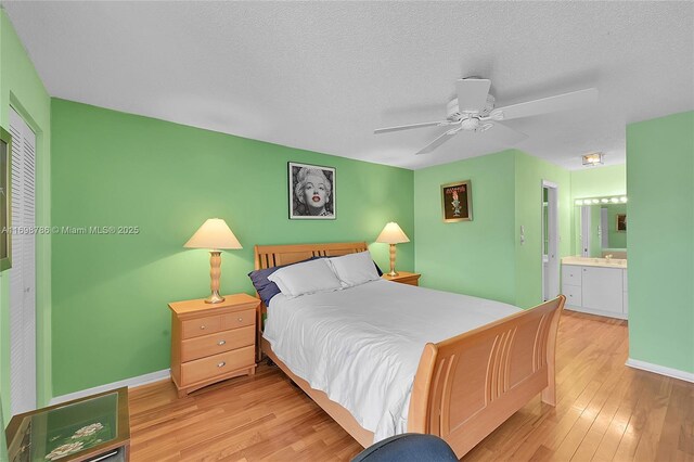 bedroom featuring visible vents, a textured ceiling, a ceiling fan, and wood finished floors