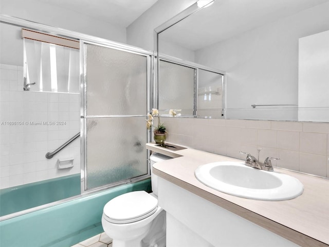 full bathroom with vanity, toilet, bath / shower combo with glass door, and backsplash