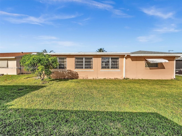 back of property featuring a lawn