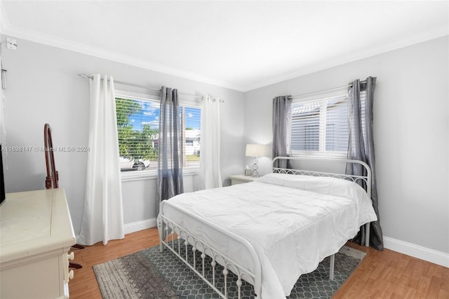 bedroom with crown molding and wood-type flooring