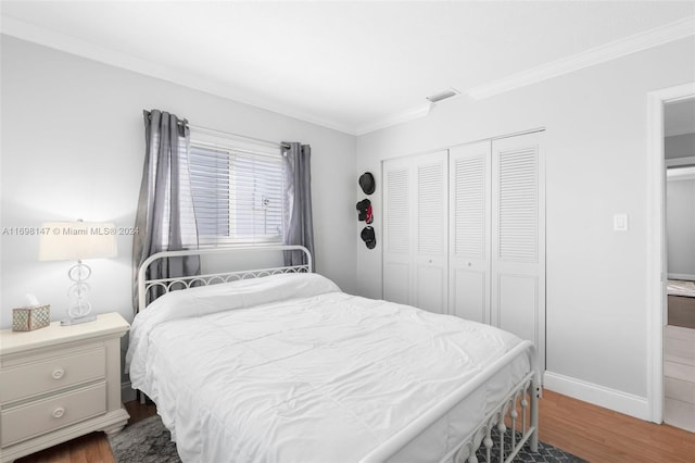 bedroom featuring dark hardwood / wood-style flooring, a closet, and ornamental molding