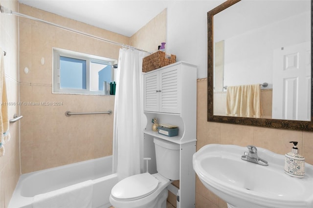 full bathroom with shower / bath combination with curtain, toilet, sink, and tile walls