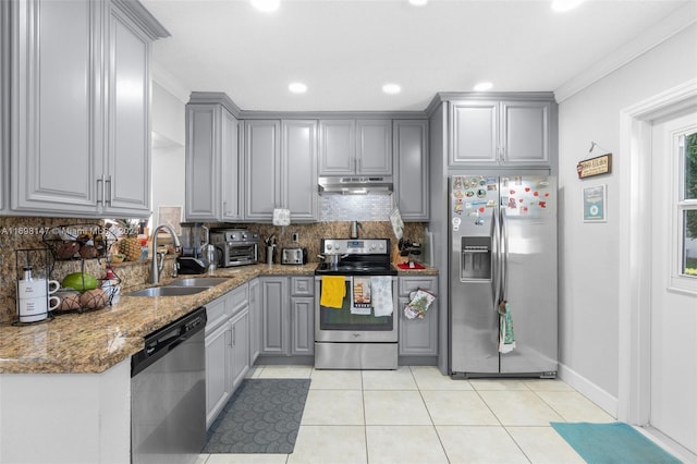 kitchen with gray cabinetry, stone counters, sink, ornamental molding, and stainless steel appliances