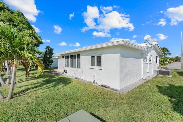 view of home's exterior with a yard and cooling unit