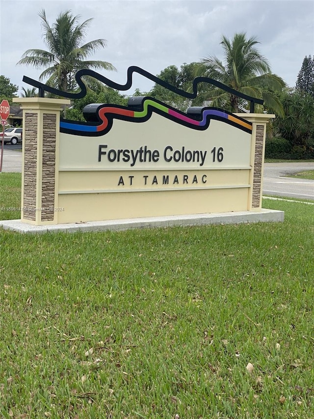 community sign featuring a lawn