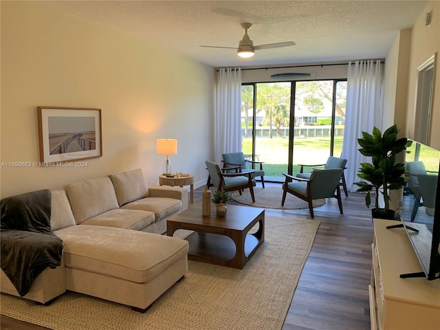 living room with ceiling fan, a textured ceiling, and hardwood / wood-style flooring