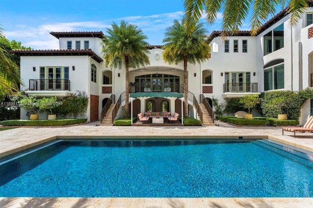 rear view of property featuring outdoor lounge area and a patio