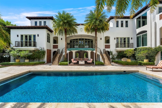 3305 S Moorings Way, Miami, FL 33133 - back of property featuring stairs, a patio area, stucco siding, an outdoor pool, and an outdoor living space
