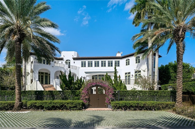 3305 S Moorings Way, Miami, FL 33133 - view of front of home featuring stucco siding, a chimney, a fenced front yard, and a gate