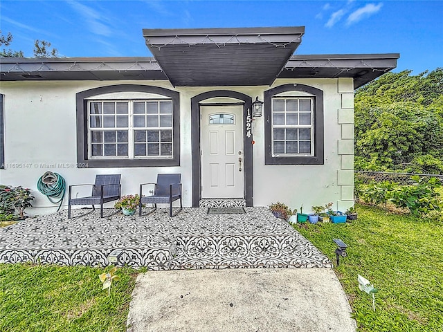 doorway to property featuring a lawn