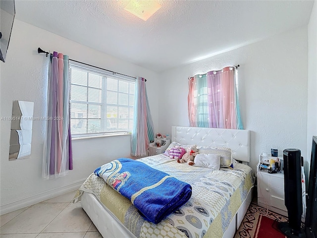 bedroom with a textured ceiling and light tile patterned flooring