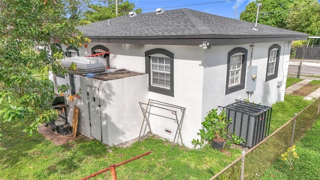 view of property exterior featuring central AC unit and a lawn