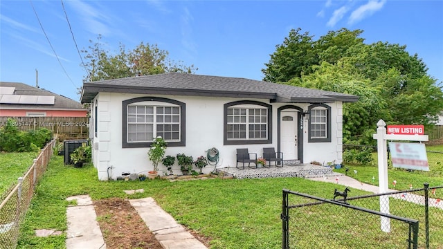 view of front of house featuring central AC unit and a front lawn