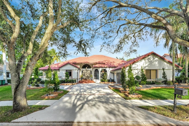 mediterranean / spanish home featuring a front lawn