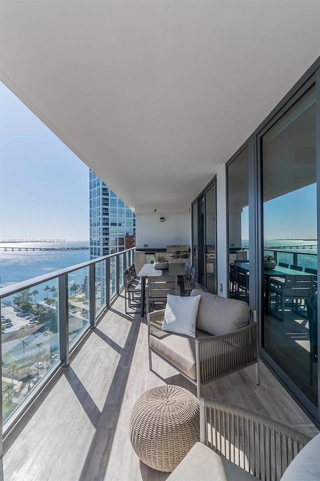 balcony featuring outdoor lounge area and a water view