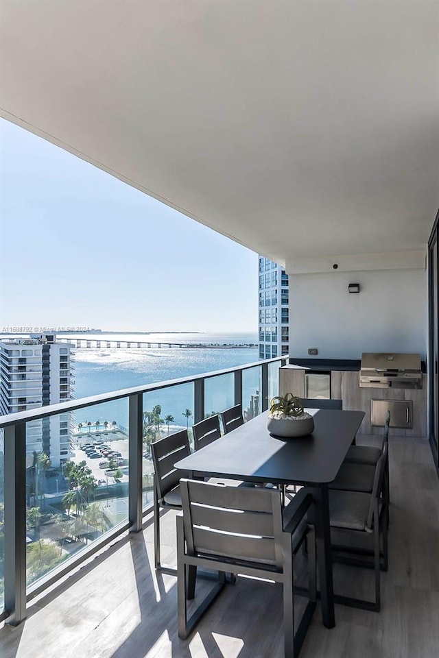 balcony with a water view and area for grilling