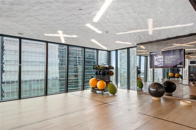 workout room featuring expansive windows and hardwood / wood-style flooring