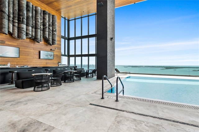 view of swimming pool with a patio area, an outdoor living space, and a water view