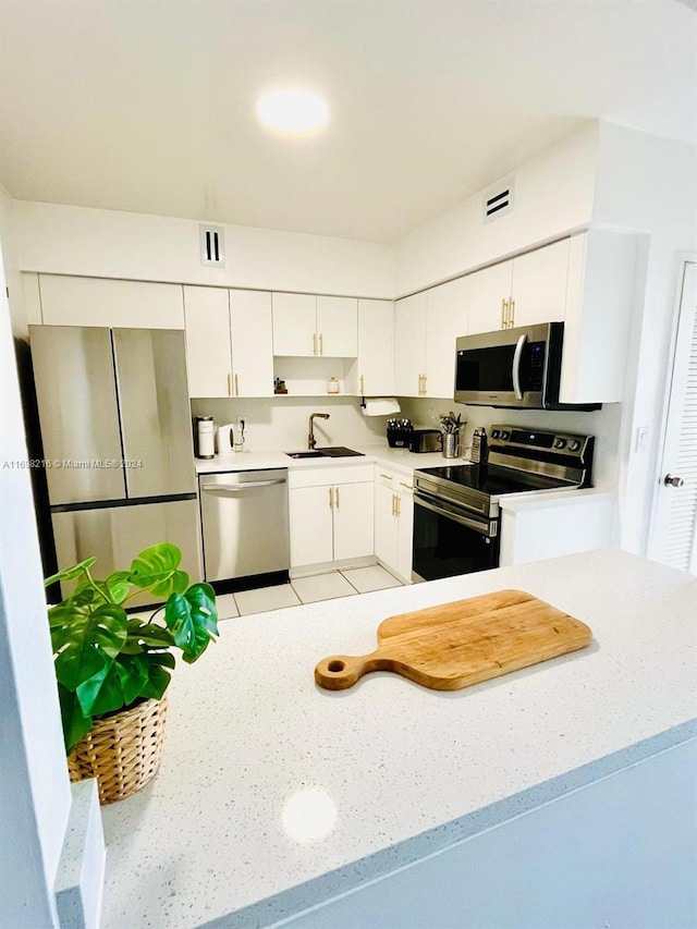 kitchen with white cabinets, appliances with stainless steel finishes, and sink