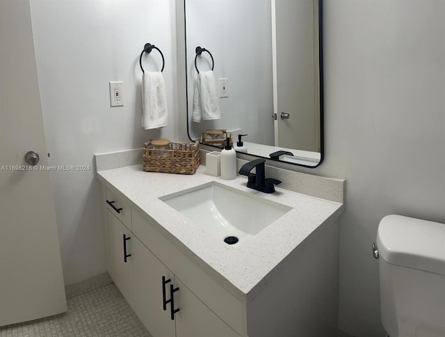 bathroom with tile patterned flooring, vanity, and toilet