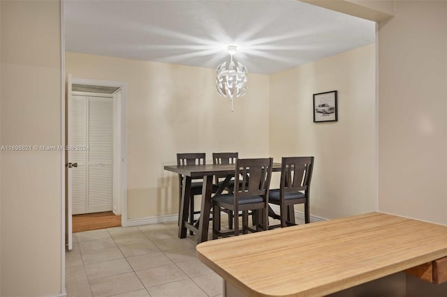 dining room with a chandelier and light tile patterned floors