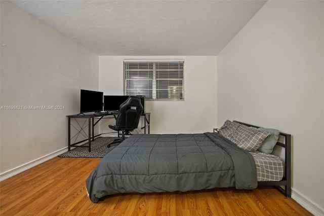 bedroom featuring wood-type flooring and a textured ceiling