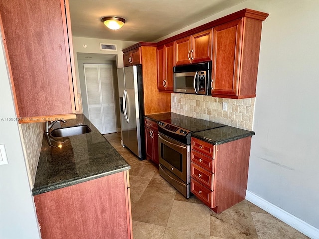 kitchen with visible vents, backsplash, appliances with stainless steel finishes, a sink, and dark stone counters