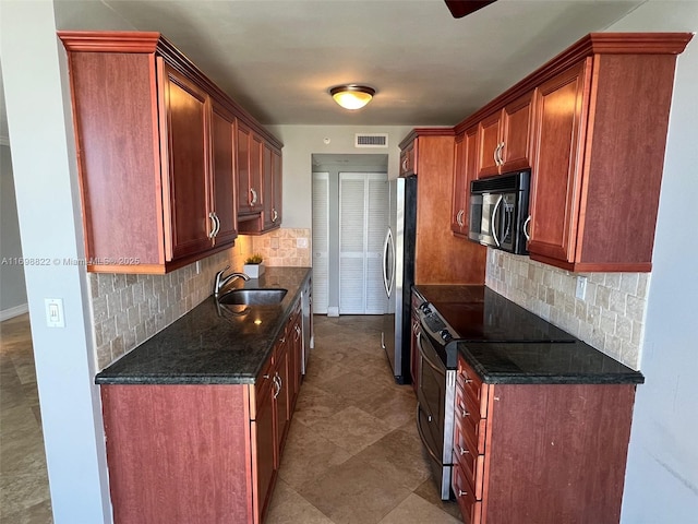 kitchen with a sink, visible vents, appliances with stainless steel finishes, tasteful backsplash, and dark stone countertops