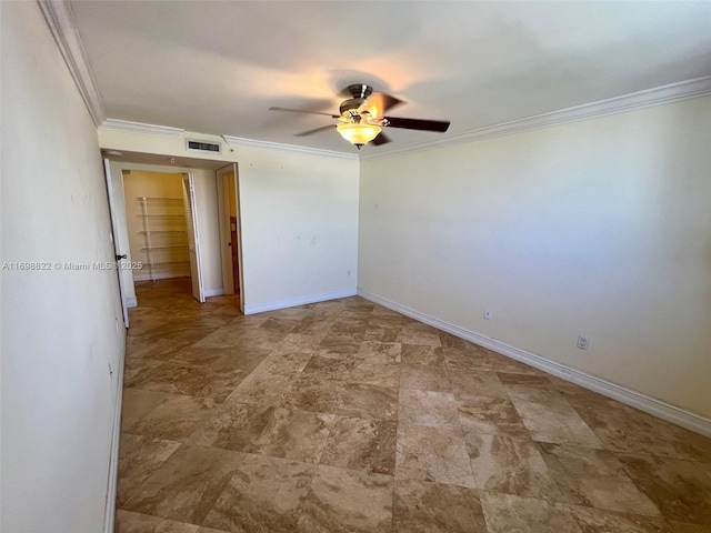 empty room featuring a ceiling fan, visible vents, crown molding, and baseboards