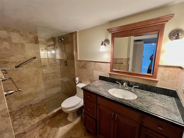 bathroom with vanity, tile walls, toilet, and a walk in shower