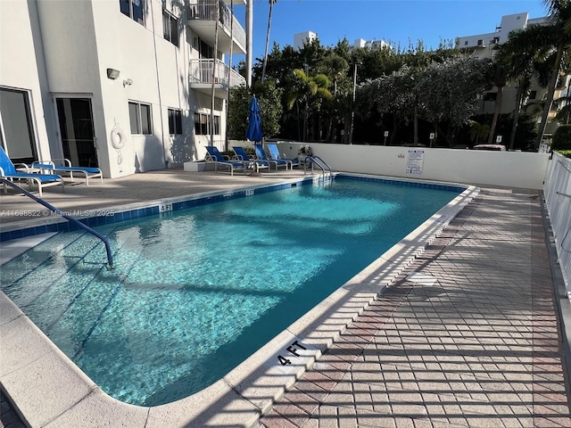 community pool featuring a patio area and fence