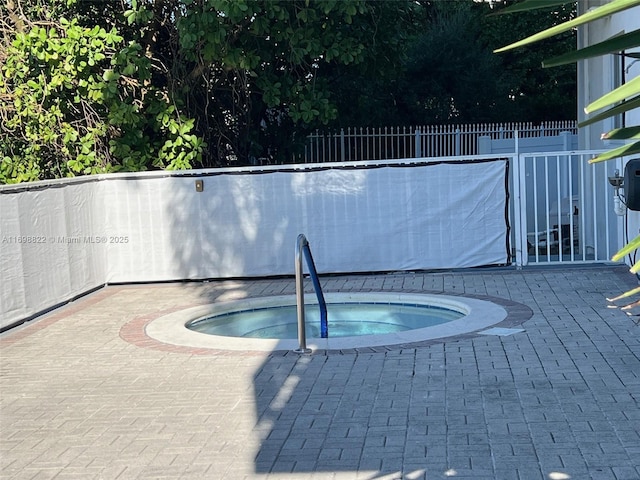 view of pool featuring fence, a patio, and an in ground hot tub