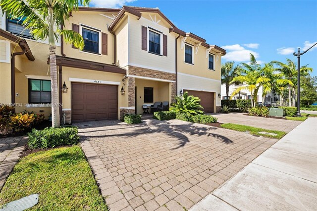 4641 Caspian Way, Davie, FL 33314 - townhome / multi-family property featuring stone siding, a garage, decorative driveway, and stucco siding